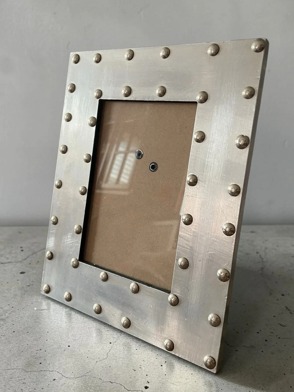 Stonebriar frame, distressed metal, prominent rivets, industrial style, pewter?